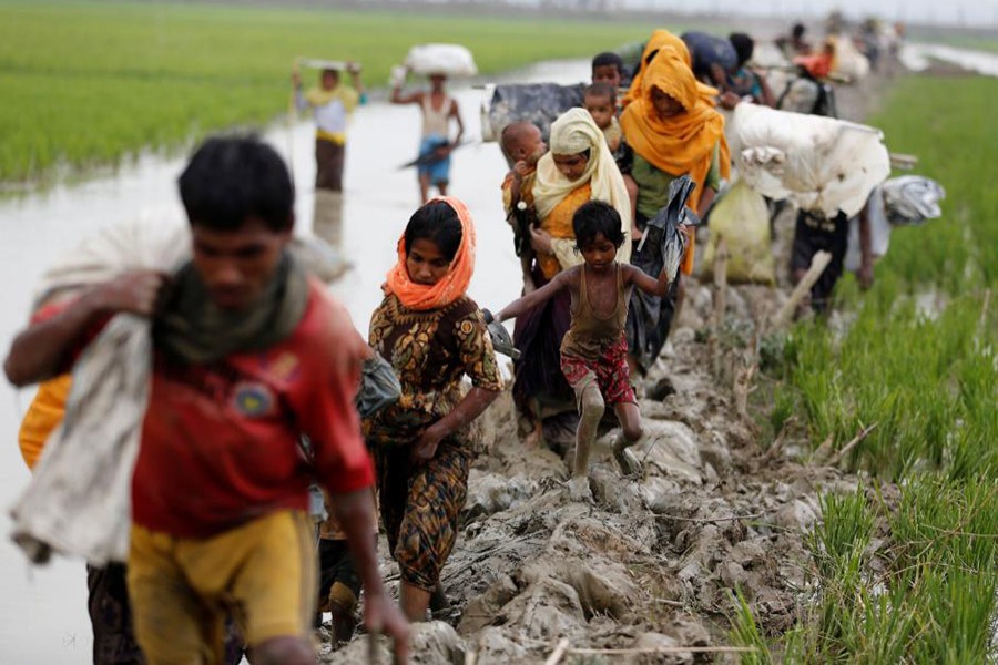 Rohingya refugees walk on the muddy path after crossing the Bangladesh-Myanmar border in Teknaf, Bangladesh on Sunday. - Reuters photo