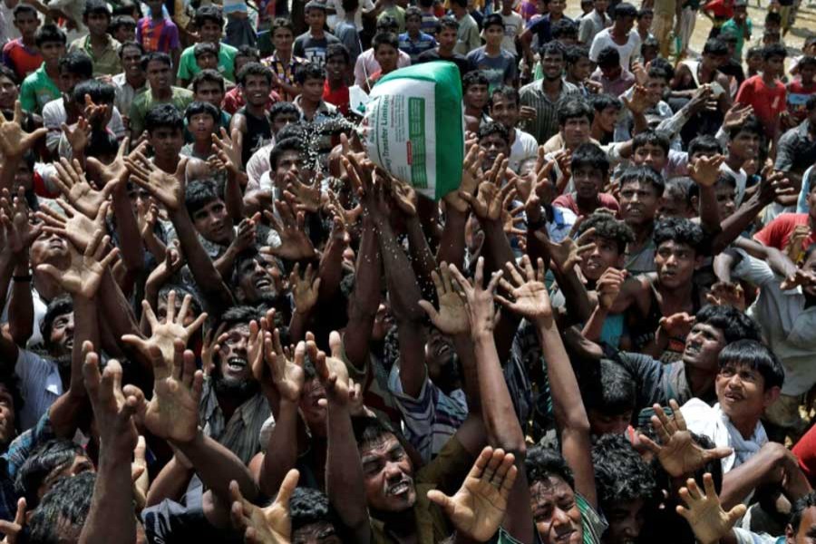 Rohingya refugees react as aid is distributed in Cox's Bazar, Bangladesh, September 21, 2017.   - Reuters