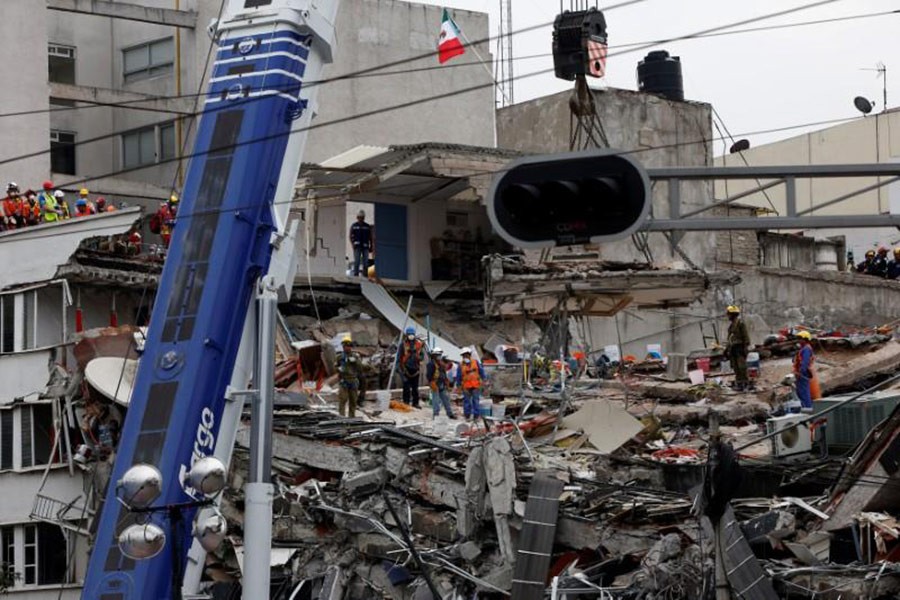 Rescue teams remove a platform as they search for survivors in a collapsed building after an earthquake at Roma neighborhood in Mexico City, Mexico on Saturday. - Reuters