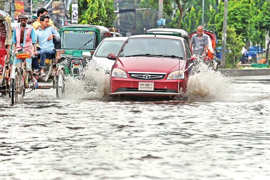 Vehicles ply the Fakirerpul area in the city where roads went under water after rain on Friday. 	— FE photo