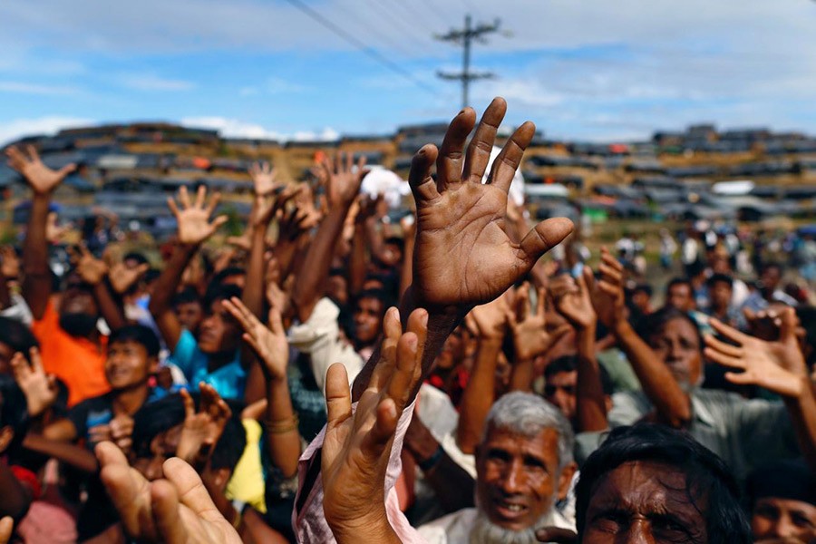 Rohingya refugees stretch their hands to receive aid distributed by local organisations at Balukhali makeshift refugee camp in Cox's Bazar, Bangladesh, September 14 last. - Reuters file photo