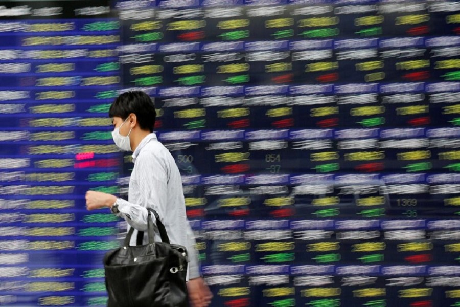 A man walks past an electronic stock quotation board outside a brokerage in Tokyo, Japan, September 22, 2017. Reuters