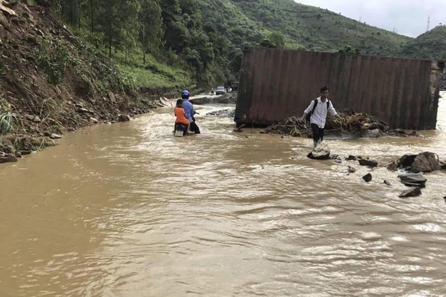 Residents wade through flood water in northern province of Son La, Vietnam on Thursday. -AP Photo