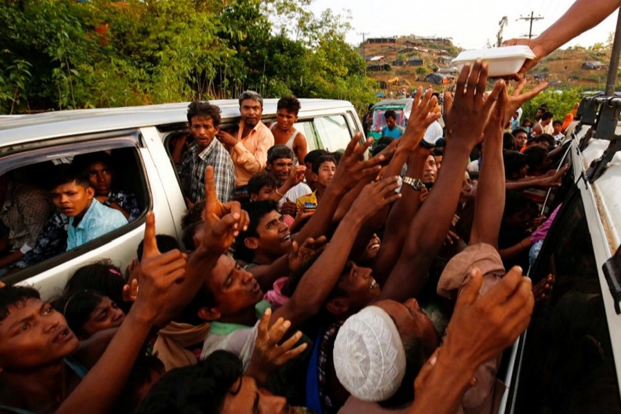 Rohingya refugees stretch their hands for food near Balukhali in Cox’s Bazar, Bangladesh, September 4, 2017. Reuters