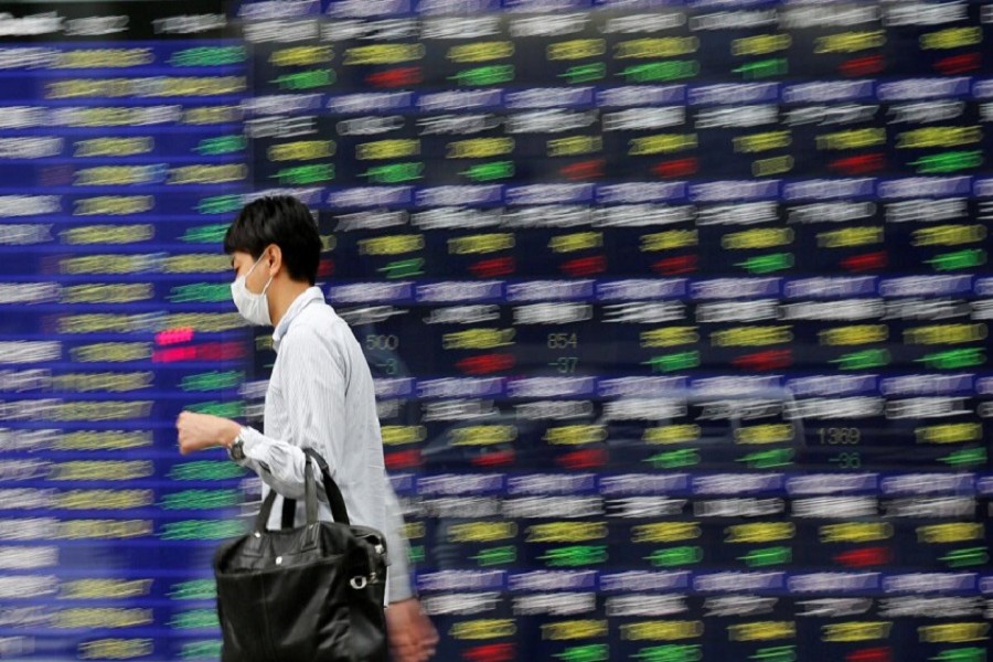 A man walks past an electronic stock quotation board outside a brokerage in Tokyo, Japan, September 22, 2017. Reuters/File Photo