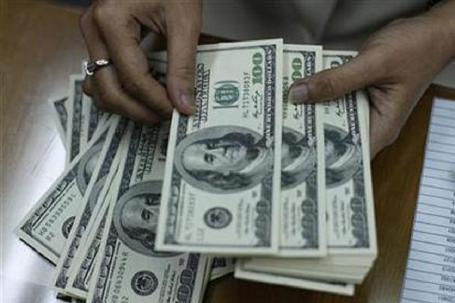 An employee is seen counting US dollar notes at a money changer in this photo: Reuters