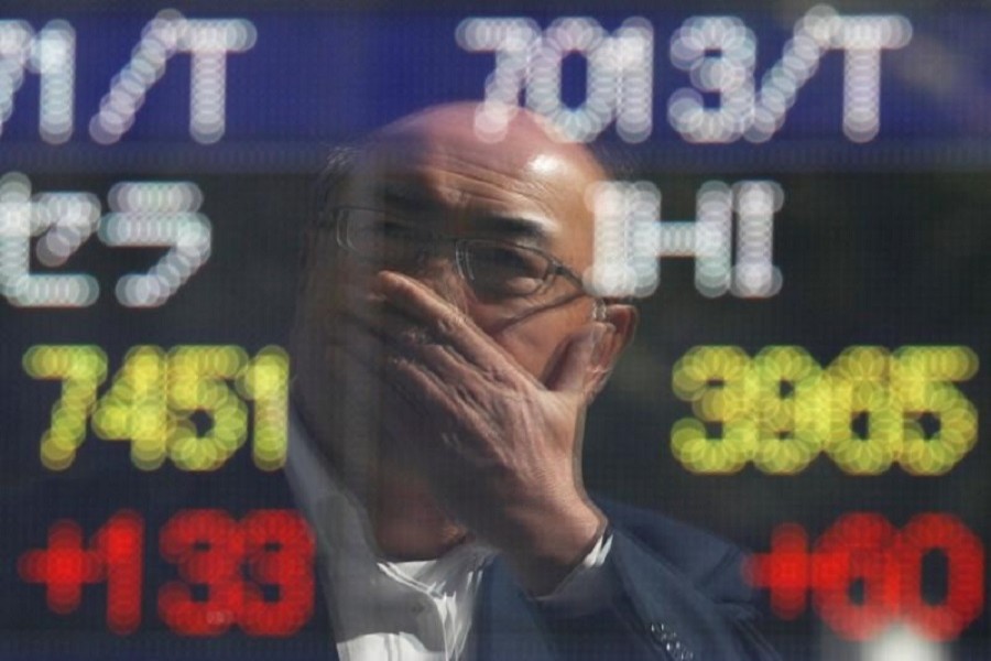 A man is reflected in an electronic stock quotation board outside a brokerage in Tokyo, Japan, October 23, 2017. Reuters