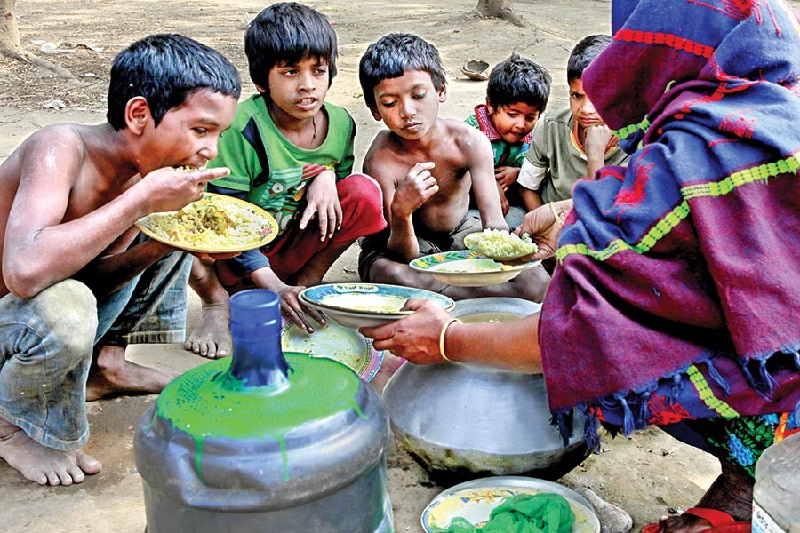 Street children have food sold by a woman at Suhrawardy Udyan in the city. — FE photo by Shafiqul Alam