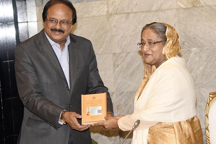 NBR Chairman Md Nojibur Rahman hands over income tax card to Prime Minister Sheikh Hasina at the PMO in Dhaka on Monday. -Focus Bangla Photo