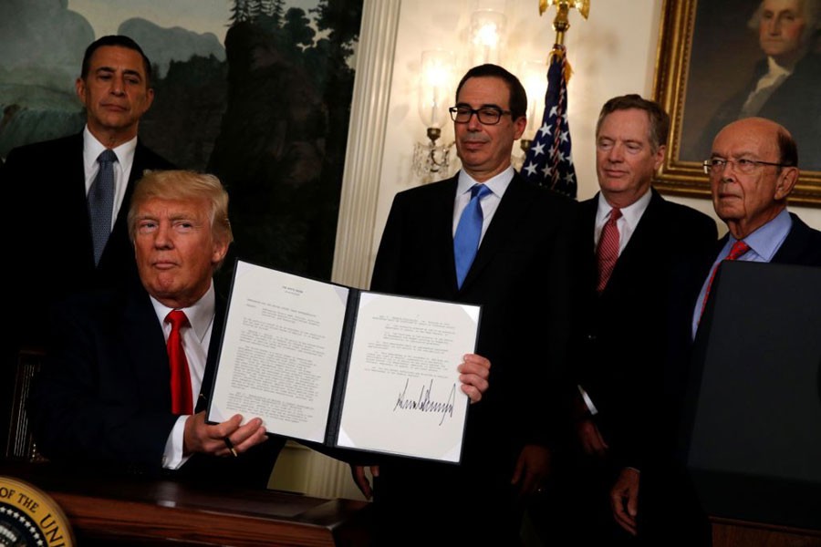 Trump finishes signing a memorandum directing the US Trade Representative to complete a review of trade issues with China at the White House in Washington. - Photo: Reuters