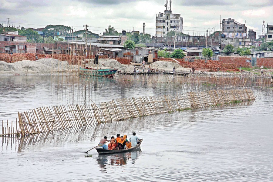 A bamboo fencing bears a testimony to the bid for grabbing an area in the Buriganga river at Kamrangir Char in the city. — File photo