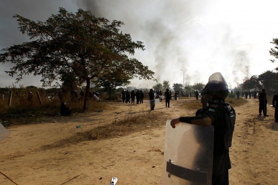 A policeman leans on his shield in the police staging area and watch demonstrators near the Faizabad junction in Islamabad, Pakistan November 25, 2017. Reuters