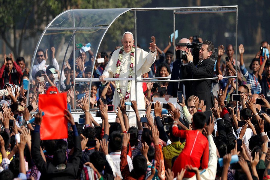 Pope Francis greets believers as he arrives for a mass in Dhaka, Bangladesh on Friday. Photo: REUTERS