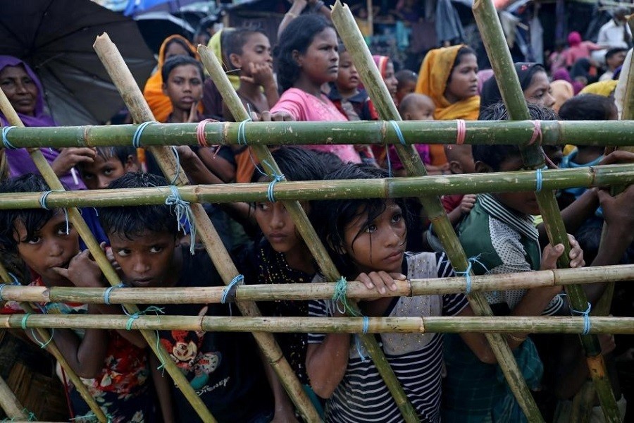 Rohingya refugees look through a fence as they wait outside of aid distribution premises at a refugee camp in Cox's Bazar, Bangladesh October 8, 2017. Reuters/Files