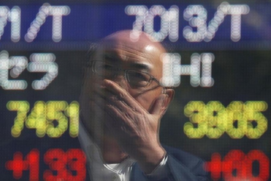 A man is reflected in an electronic stock quotation board outside a brokerage in Tokyo, Japan, October 23, 2017. Reuters/File Photo