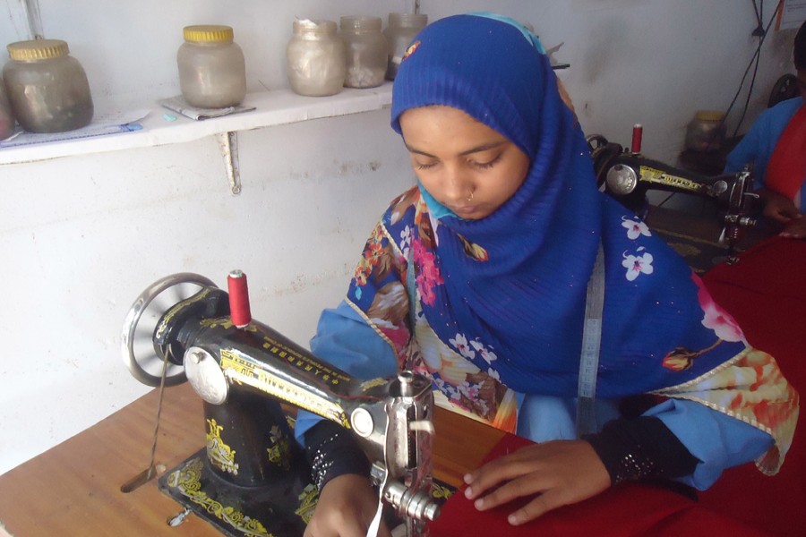 Shikha operates a sewing machine on Thursday. 	— FE Photo