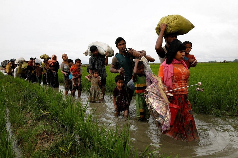 A group of Rohingya refugee people walk in the water after crossing the Bangladesh-Myanmar border in Teknaf, Bangladesh, September 1, 2017. Reuters