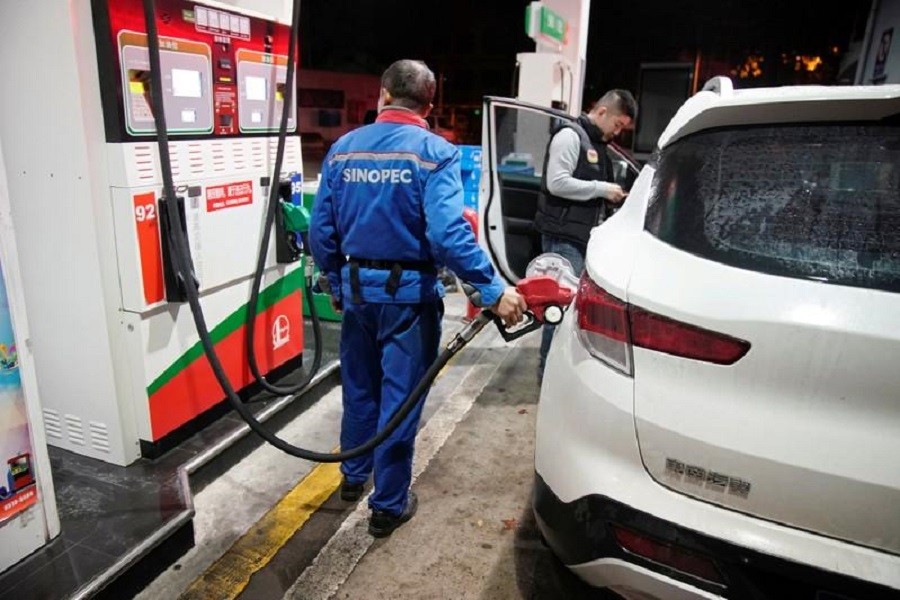 A gas station attendant pumps fuel into a customer's car at a gas station in Shanghai, China November 17, 2017. Reuters/Files