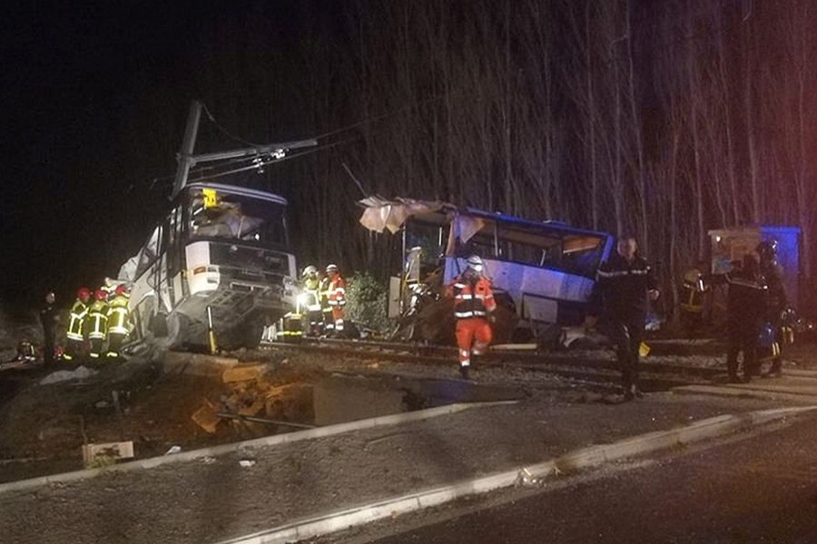 Rescue workers are seen on the site of collision between train and school bus in Millas, France on Thursday. - Reuters