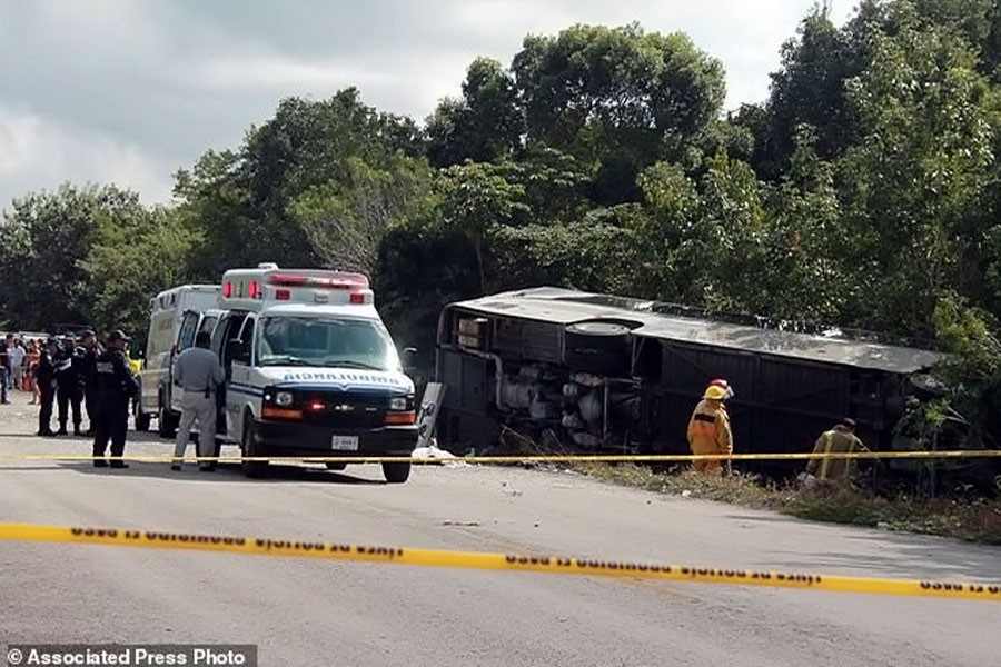 An ambulance sits parked next to an overturned bus in Mahahual, Quintana Roo state, Mexico, Tuesday, Dec 19, 2017. (AP Photo)