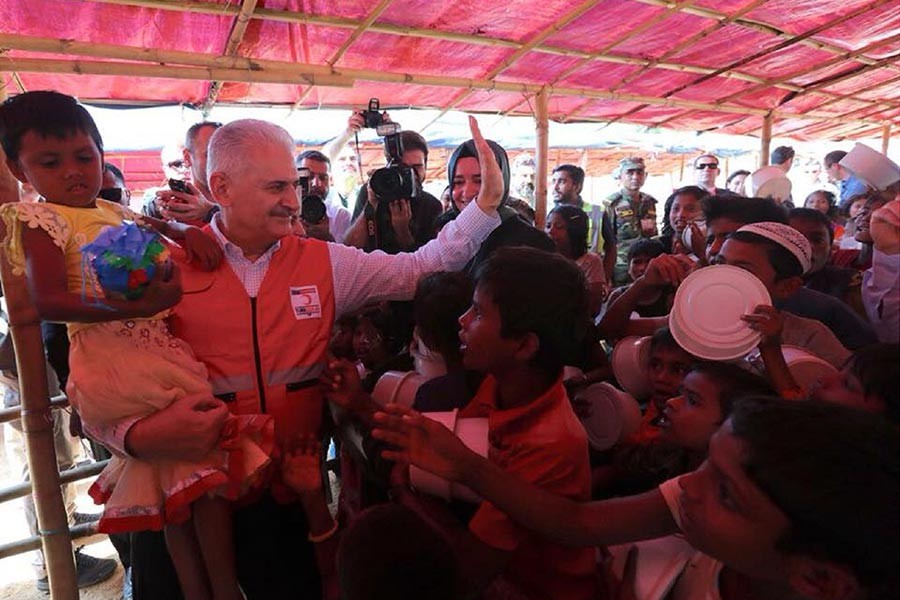 Turkish Prime Minister Binali Yildirim took a baby on his lap while visiting different Rohingya camps in Cox's Bazar on Wednesday.