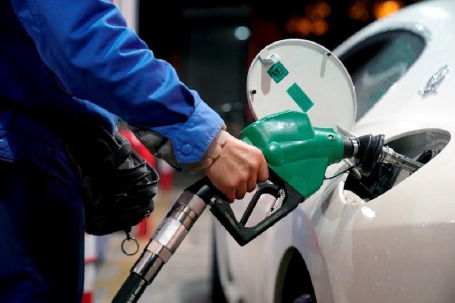 A gas station attendant pumps fuel into a customer's car at a gas station in Shanghai, China November 17, 2017. Reuters