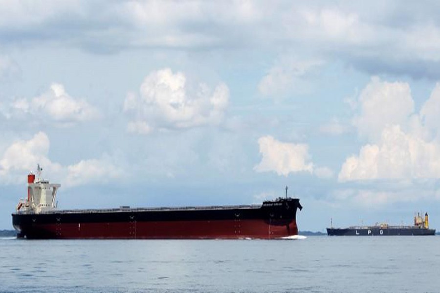 The bulk carrier 'Midnight Dream' sails past an LPG tanker near the Raffles Lighthouse in southern Singapore. 	— Reuters