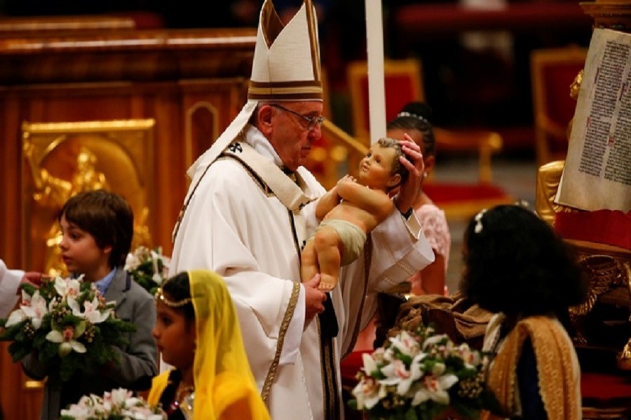 Pope Francis holds a statuette of baby Jesus during the traditional midnight mass in St. Peter's Basilica on Christmas Eve at the Vatican December 24, 2017. Reuters