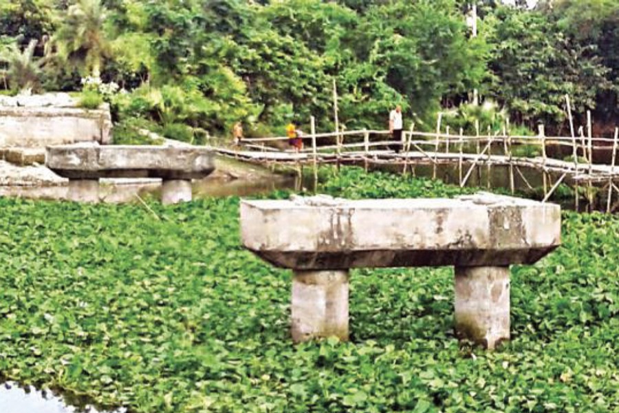 The broken bridge over the Sanchai river near Tikary Bazar under Jhenidah Sadar. A bamboo-made bridge is lying beside. 	— FE Photo