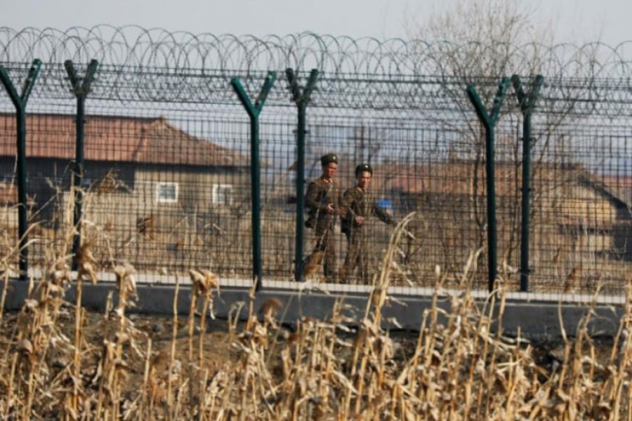 North Korean soldiers patrol behind a border fence near the North Korean town of Sinuiju, March 31, 2017. Reuters.