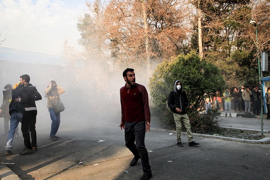 University students attend a protest inside Tehran University while a smoke grenade is thrown by anti-riot Iranian police on Saturday last. - AP file photo