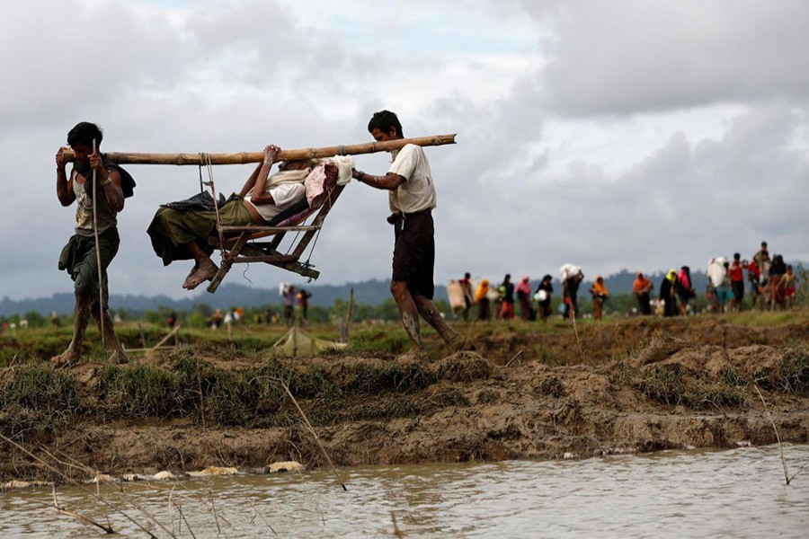 Rohingya refugee men carry an elderly man after travelling over the Bangladesh-Myanmar border in Teknaf, Bangladesh, September 1, 2017. - Reuters file photo used only for representation.