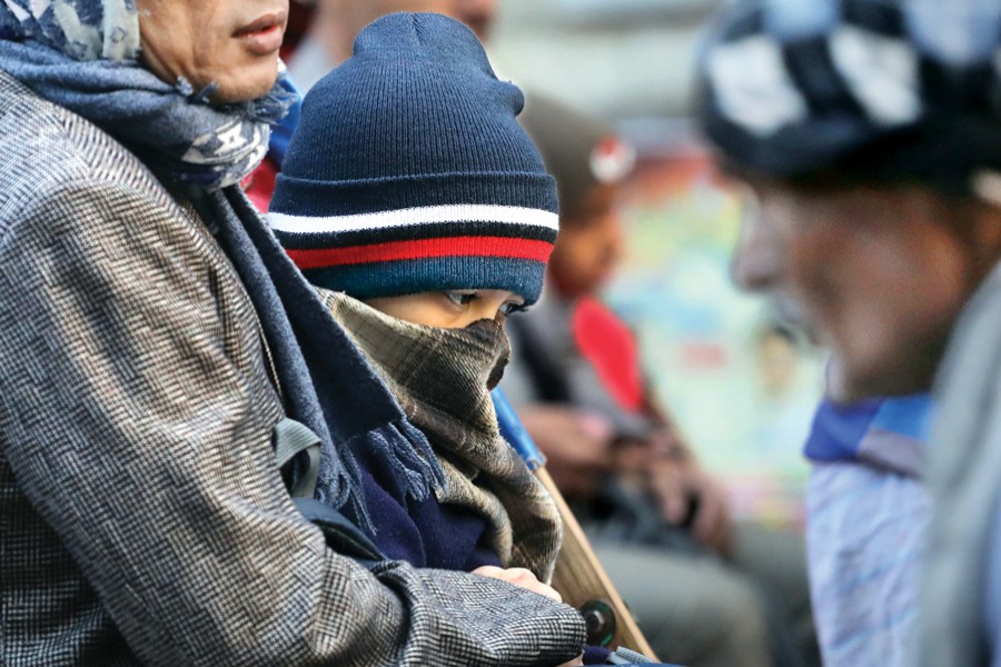 A child, on his father's lap, is well-shielded against the cold wave now sweeping over the country. This photograph was taken from Luxmibazar in Dhaka on Sunday. 	— FE photo by Shafiqul Alam