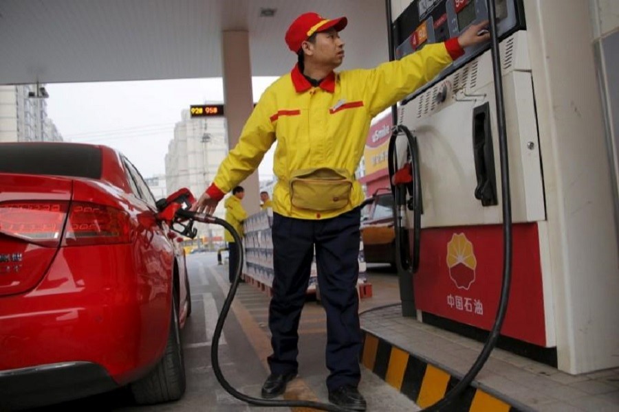 A gas station attendant pumps fuel into a customer's car at PetroChina's petrol station in Beijing, China, March 21, 2016. Reuters/File Photo