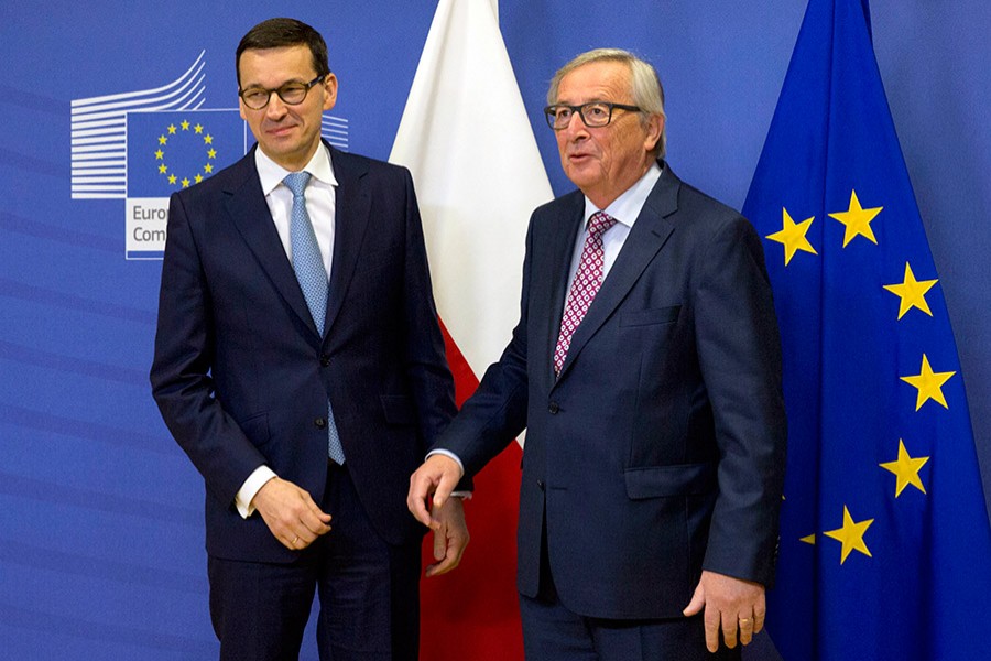 European Commission President Jean-Claude Juncker (right), greets Polish Prime Minister Mateusz Morawiecki prior to a meeting at EU headquarters in Brussels on Tuesday. - AP photo