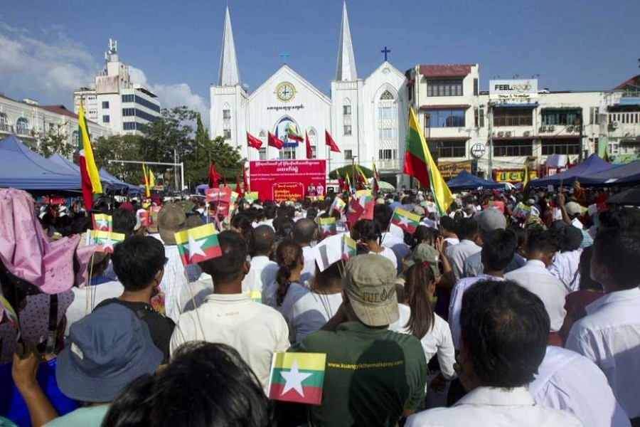 In this October 29, 2017, file photo, participants with national and military flags attend a ceremony supporting the country's military and government servants in Yangon, Myanmar. AP