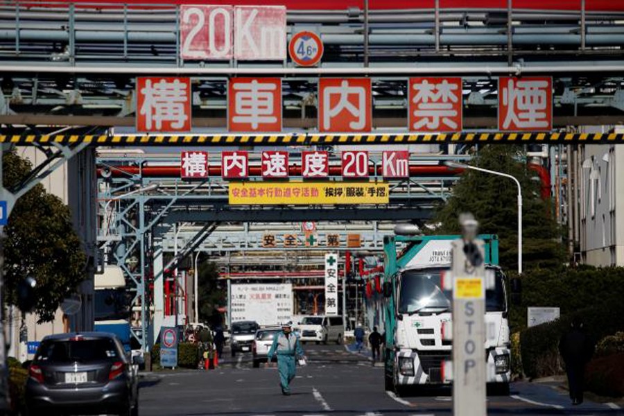 Workers walk at a factory at the Keihin industrial zone in Kawasaki, Japan. 	— Reuters