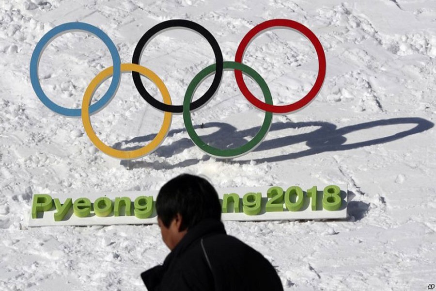 A man walks by the Olympic rings with a sign of 2018 Pyeongchang Olympic Winter Games, in Pyeongchang, South Korea, February 3, 2017. AP/File Photo