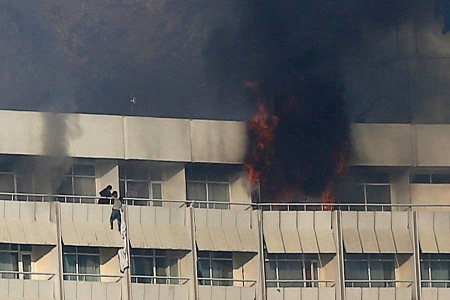 A man trying to escape attackers at Kabul's Intercontinental Hotel on Sunday. 	— Reuters