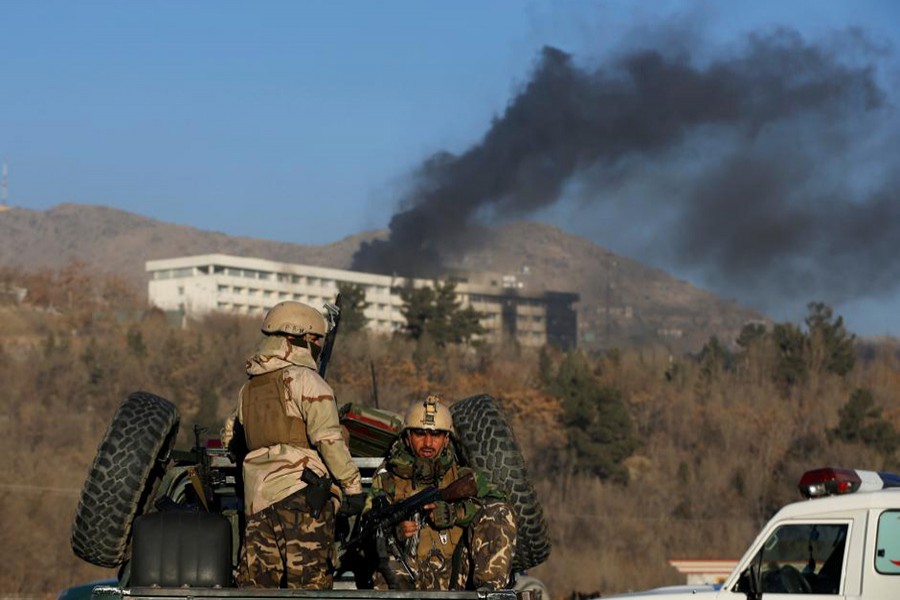 Afghan security forces keep watch as smoke rises from the Intercontinental Hotel in Kabul, Afghanistan on Sunday. - Reuters photo