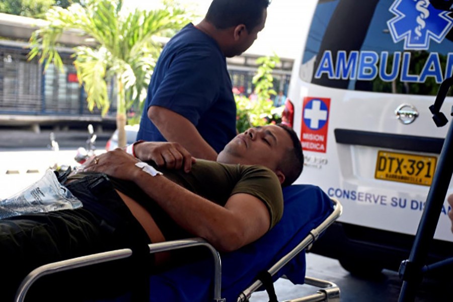 An injured policeman is carried on a stretcher by a paramedic after a bomb attack on a police station of the San Jose district, in Barranquilla, Colombia on Saturday. - Reuters photo