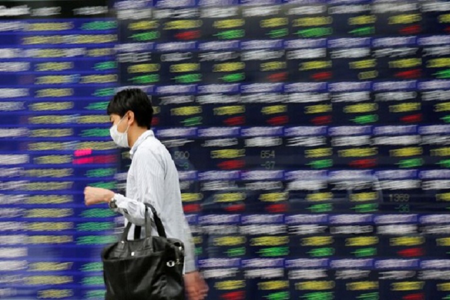 A man walks past an electronic stock quotation board outside a brokerage in Tokyo, Japan, September 22, 2017. Reuters