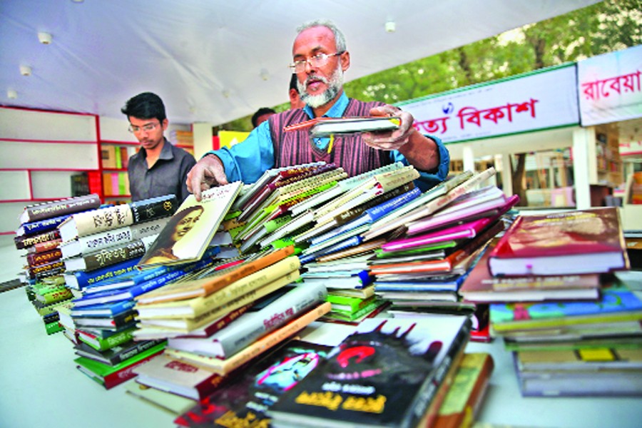 Last-minute preparations are going on to arrange books in stalls at Ekushey Book Fair- 2018 on the Bangla Academy premises in the city. The photo was snapped on Wednesday. 	— FE Photo