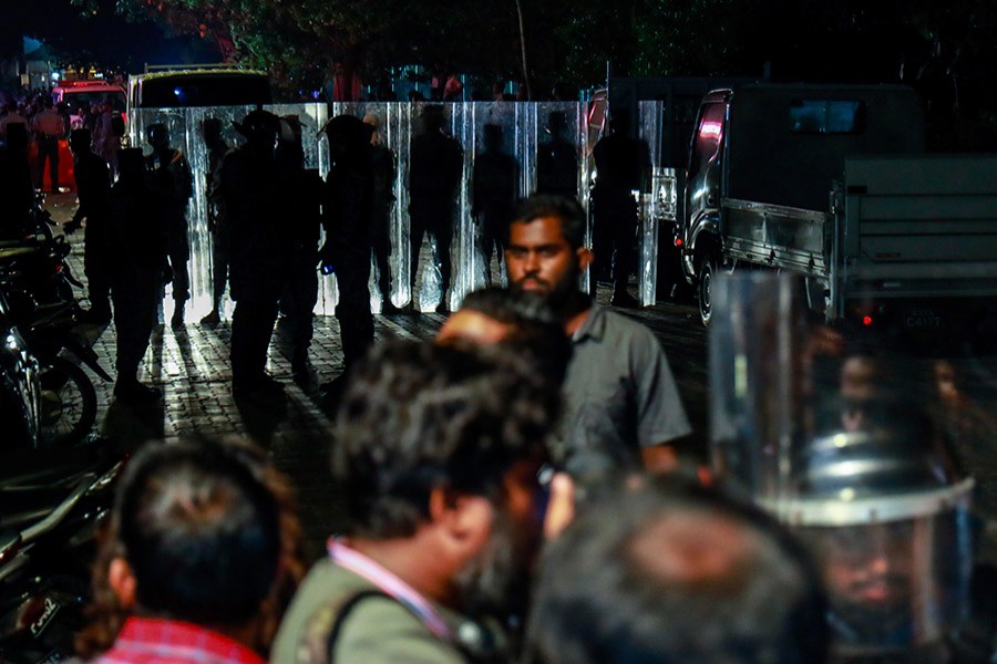 Maldivian police officers stand guard blocking a road during an opposition protest demanding the release of political prisoners in Male. - AP photo