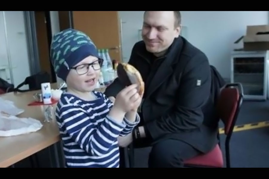 Andreas Graff smiles as he watches his son Julius play with a banana. (Image Courtesy: Anna Spiess)