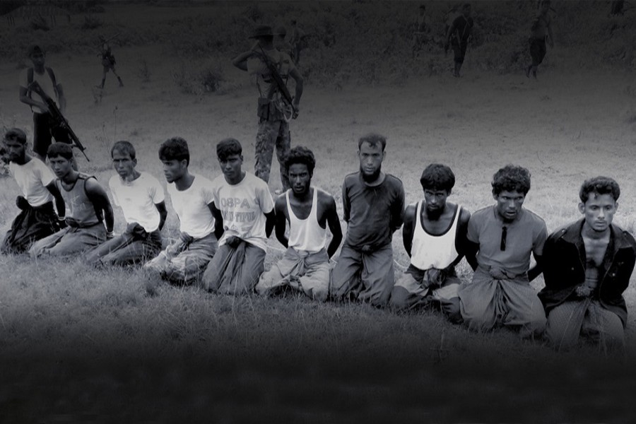 Execution: This photo was taken on the day the 10 Rohingya men were killed. Paramilitary police officer Aung Min, left, stands guard behind them. The picture was obtained from a Buddhist village elder, and authenticated by witnesses.