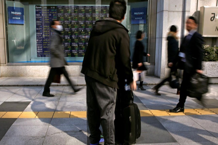 A man looks at an electronic stock quotation board outside a brokerage in Tokyo, Japan February 9, 2018. Reuters