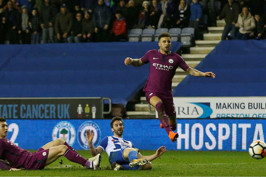 Wigan Athletic’s Will Grigg scores their first goal as Manchester City's Kyle Walker and Aymeric Laporte look on. - Reuters photo