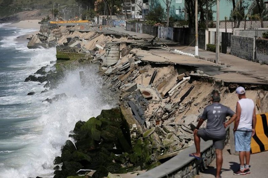 Residents look at an exposed erosion along the boardwalk of Macumba beach after waves washed away the sand in the weekend storm, in Rio de Janeiro, Brazil Oct 17, 2017. Reuters