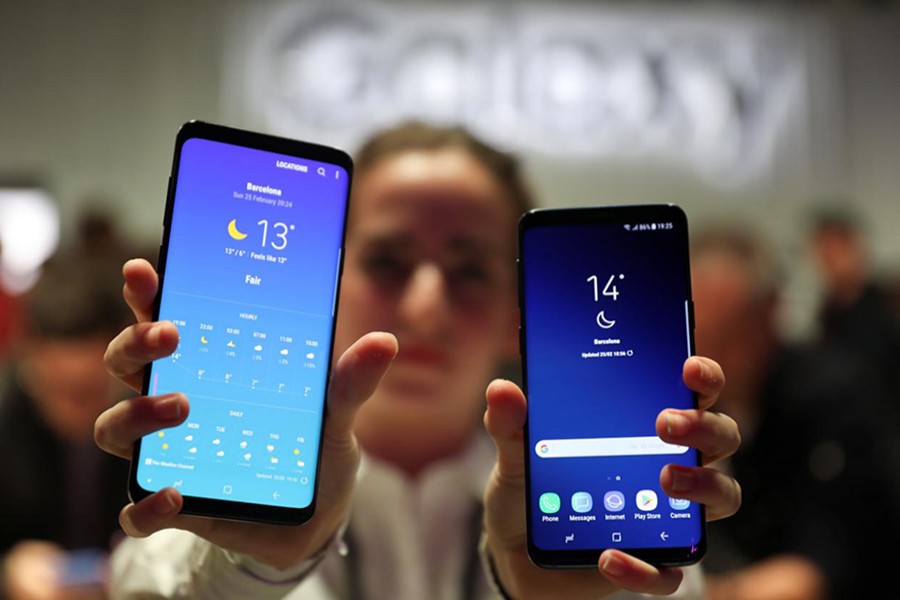 A hostess shows up Samsung's new S9 (R) and S9 Plus devices after a presentation ceremony at the Mobile World Congress in Barcelona, Spain on Sunday. - Reuters photo